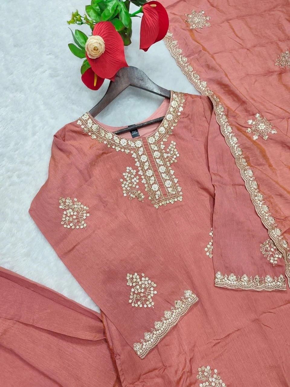 Pink traditional outfit with gold embroidery on a light blue background