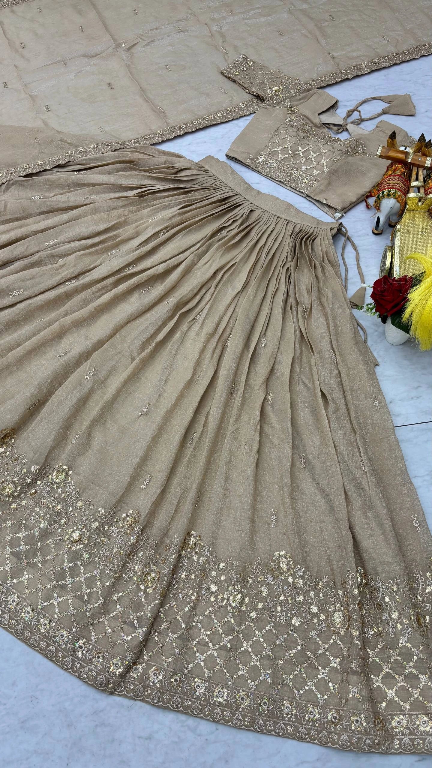 Beige saree with intricate patterns on a light gray surface
