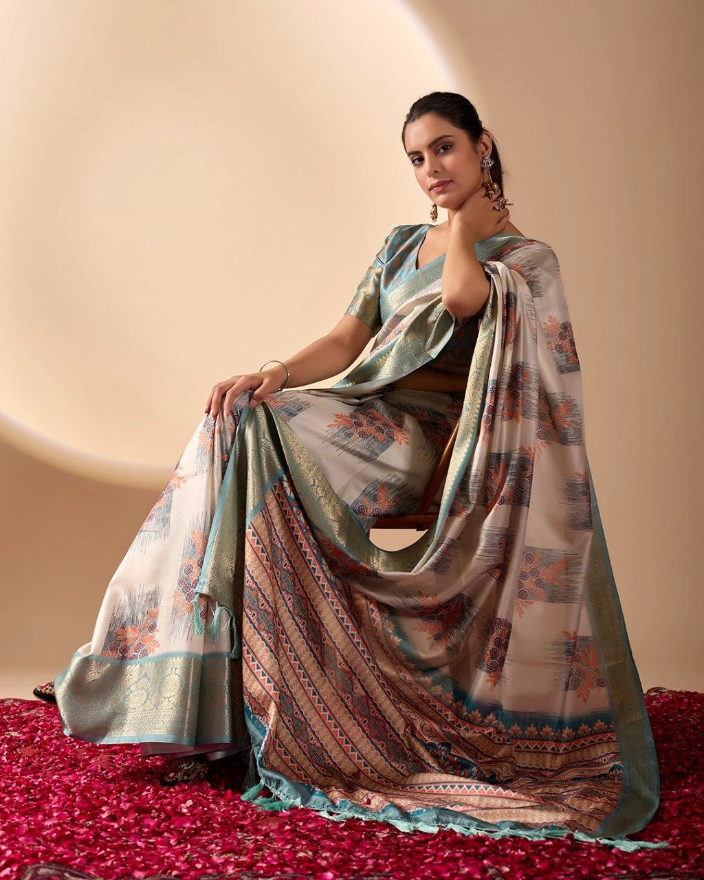 Woman wearing a traditional saree with a patterned design on a beige background