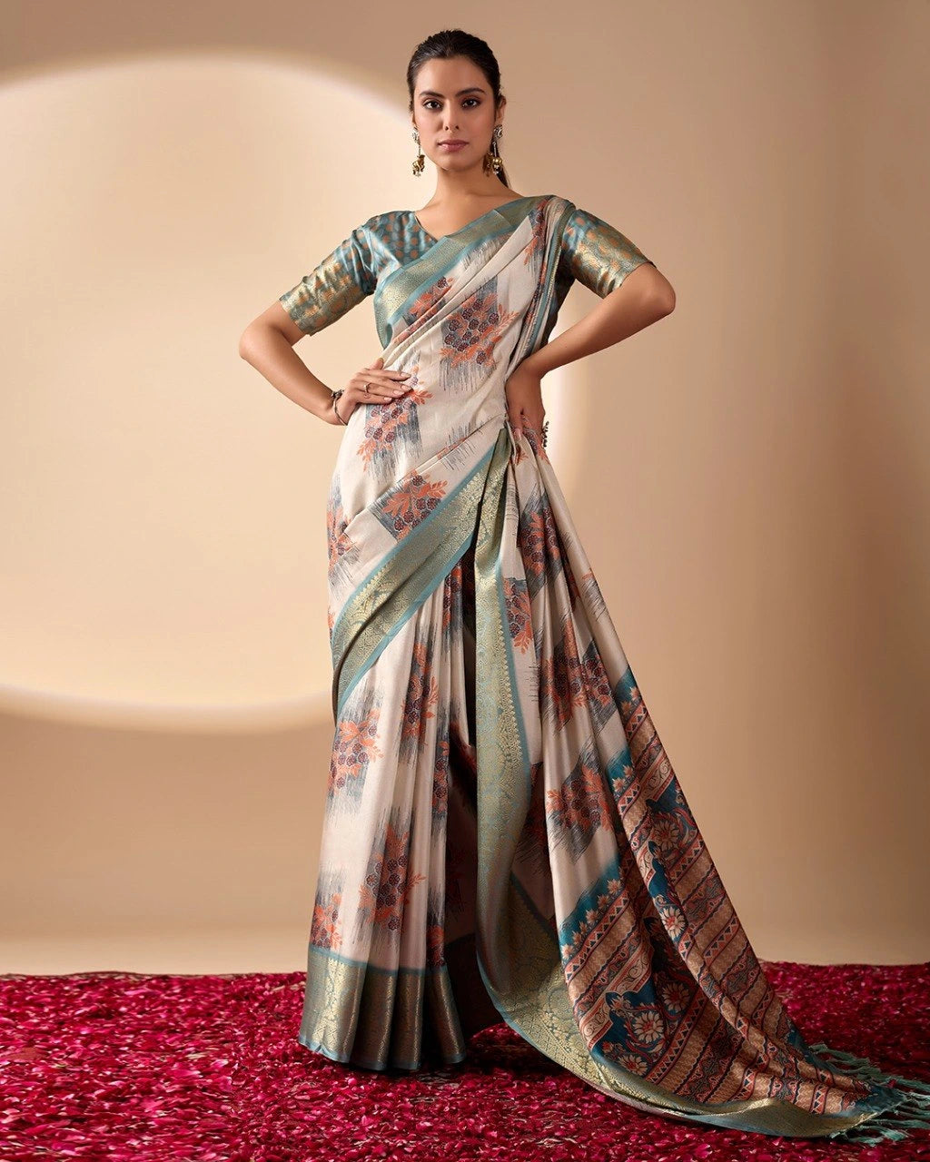 Woman wearing a traditional saree with a patterned design on a plain background