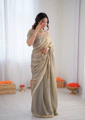 Woman wearing a beige saree with a white background