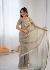Woman wearing a beige saree with a white background
