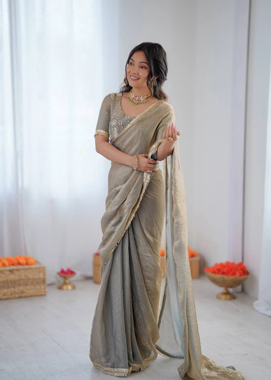 Woman wearing a saree with a neutral color palette in a minimalistic setting.