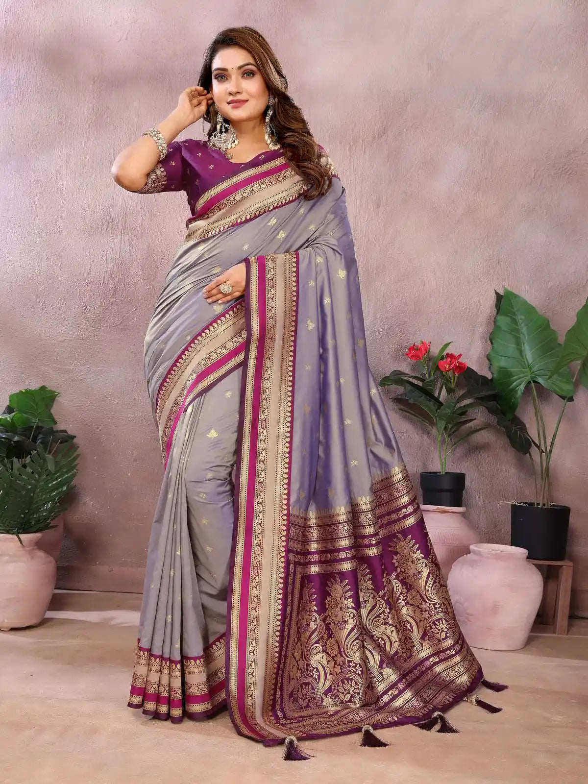 Woman wearing a traditional saree with a decorative border in a indoor setting.
