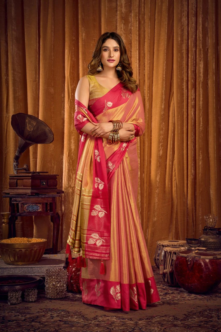 Woman in a red and gold saree standing in front of vintage decor