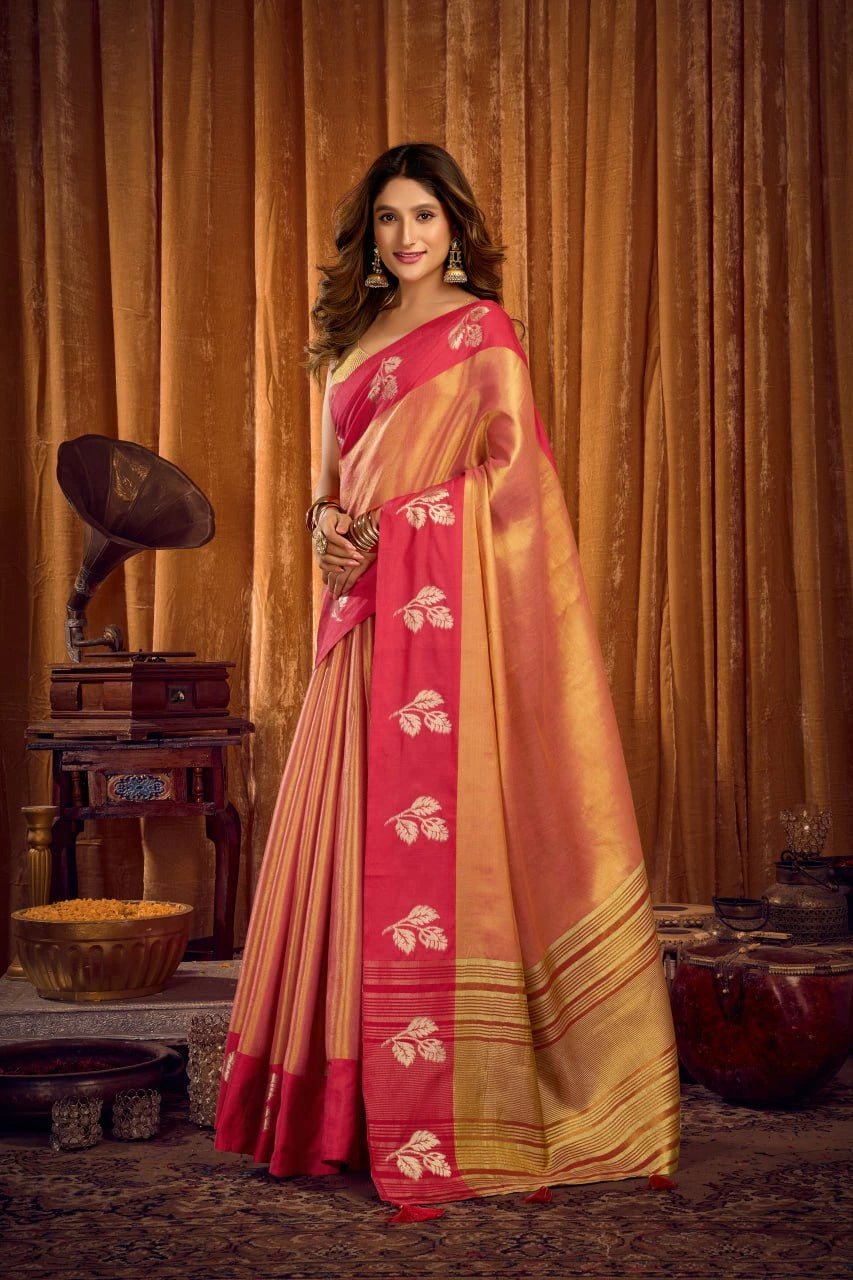 Woman in a red and gold saree standing in front of vintage decor