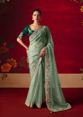Woman wearing a green saree with a red background