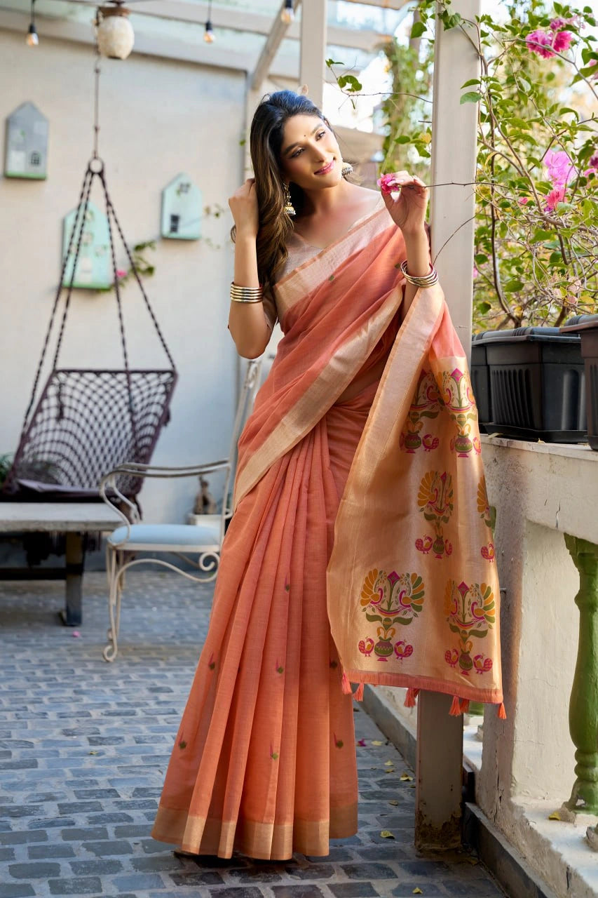 Woman in a peach saree with floral patterns standing on a patio.