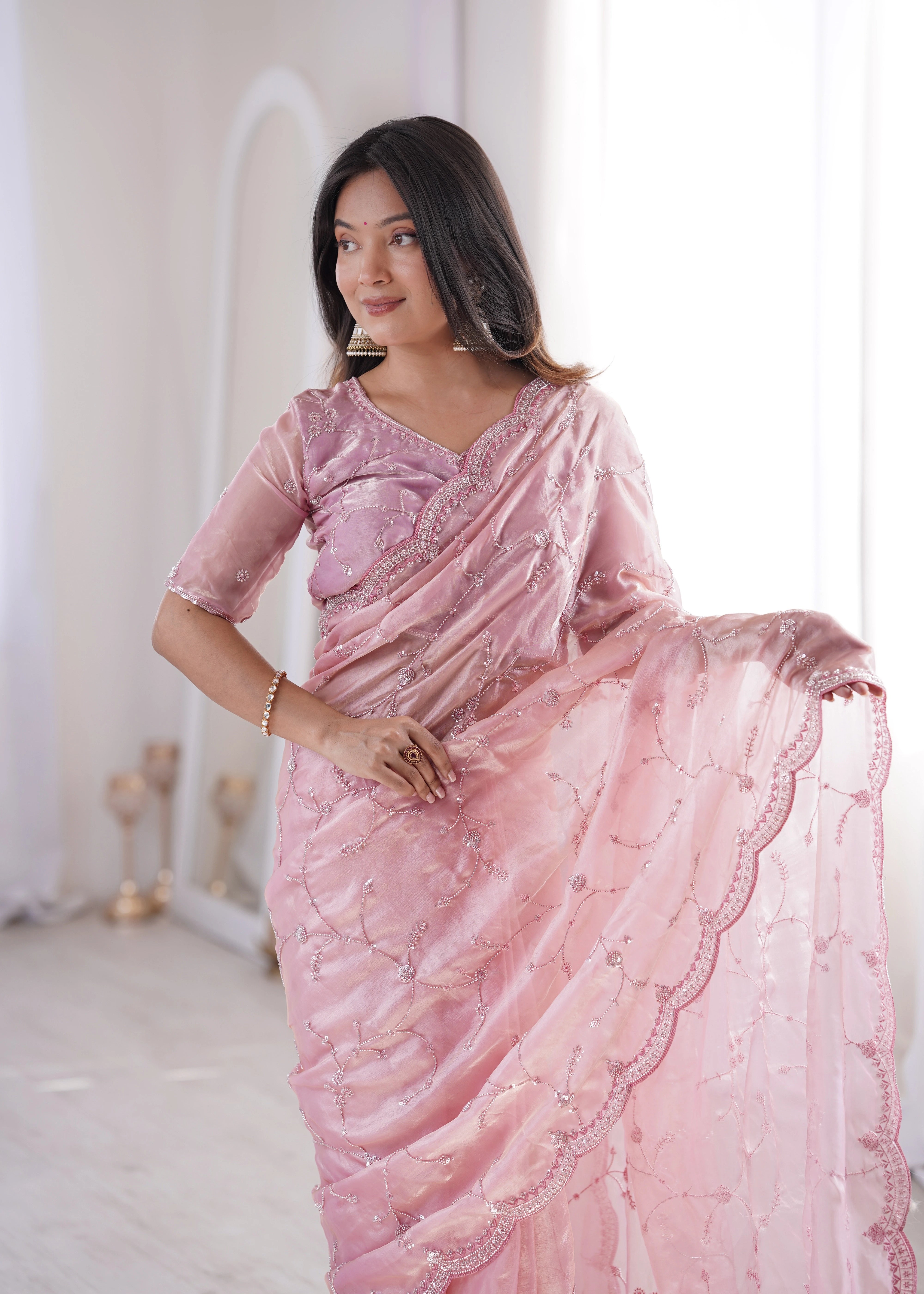 Woman wearing a pink saree with a white background
