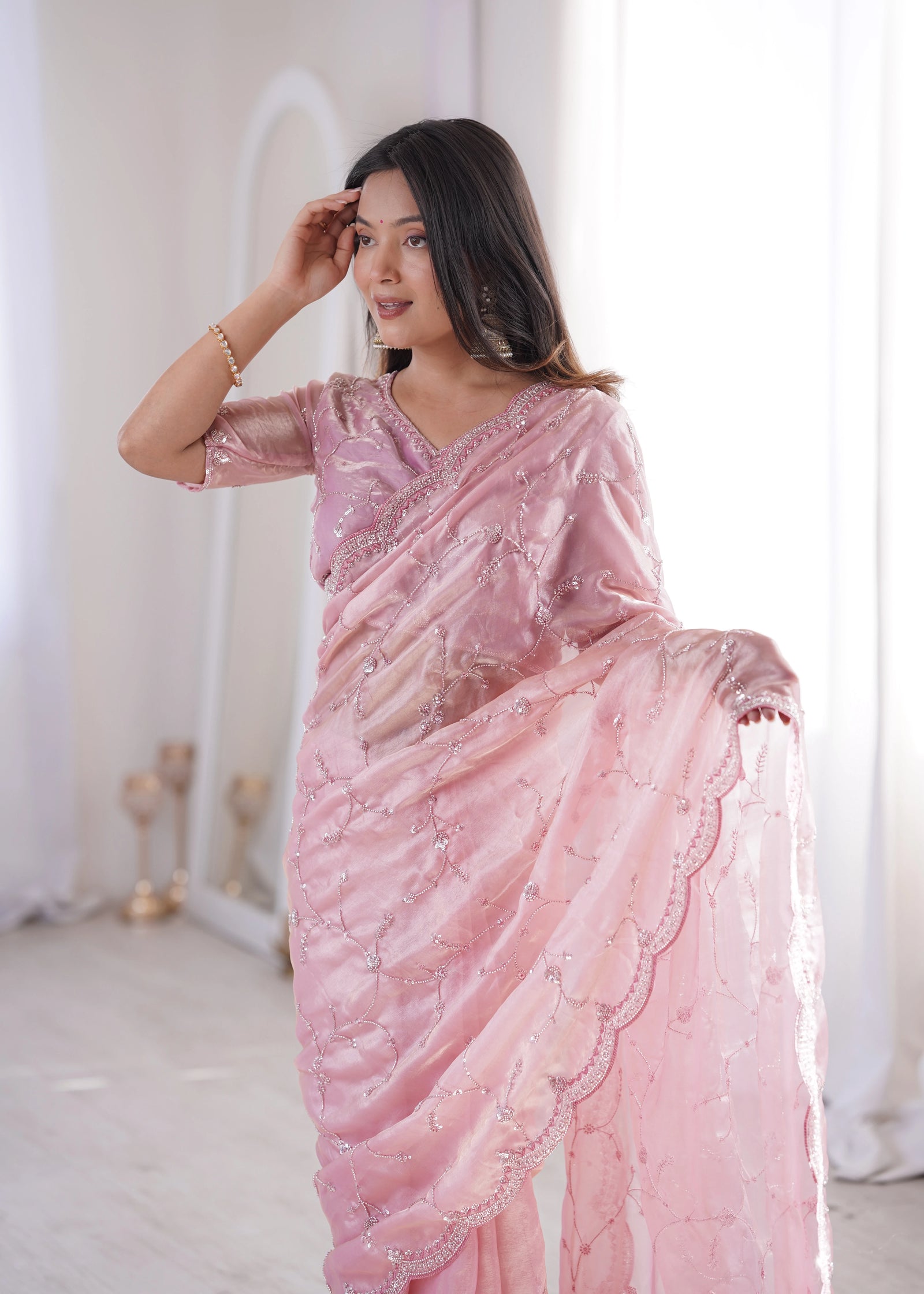Woman wearing a pink saree with a white background