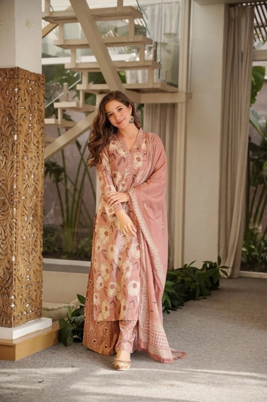 Woman in a floral dress standing in an indoor setting with decorative elements.
