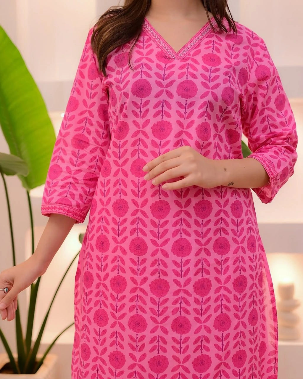 Person wearing a pink patterned dress with a blurred background