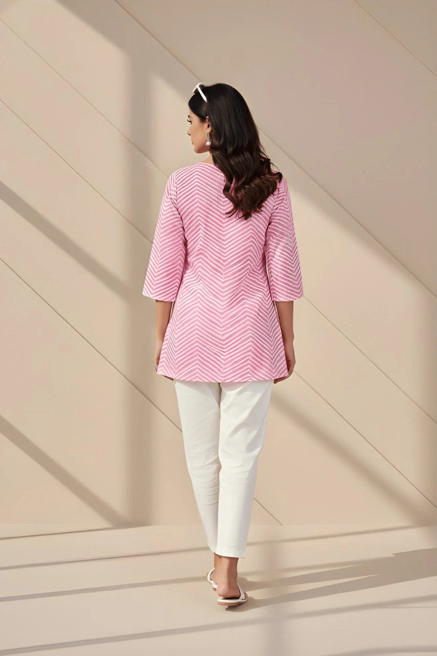 Light pink short kurti folded neatly, showcasing soft fabric and printed details.