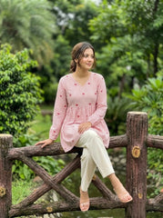 Woman sitting on a wooden fence in a garden