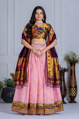 Woman wearing a traditional outfit with a pink skirt and gold blouse against a white wall.