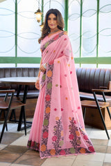 Woman wearing a pink saree with floral patterns in an indoor setting