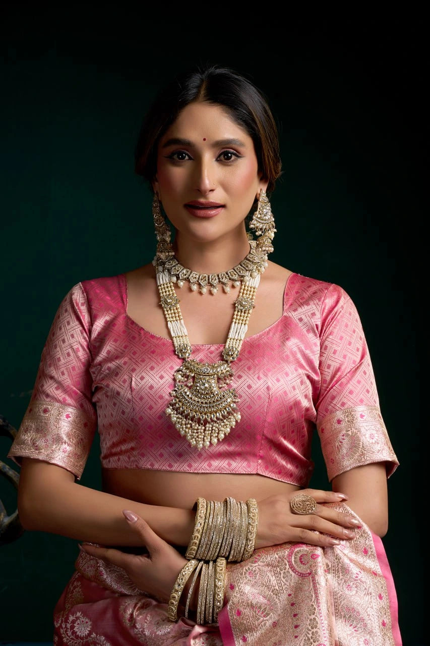 Woman in a pink traditional outfit with jewelry against a dark background