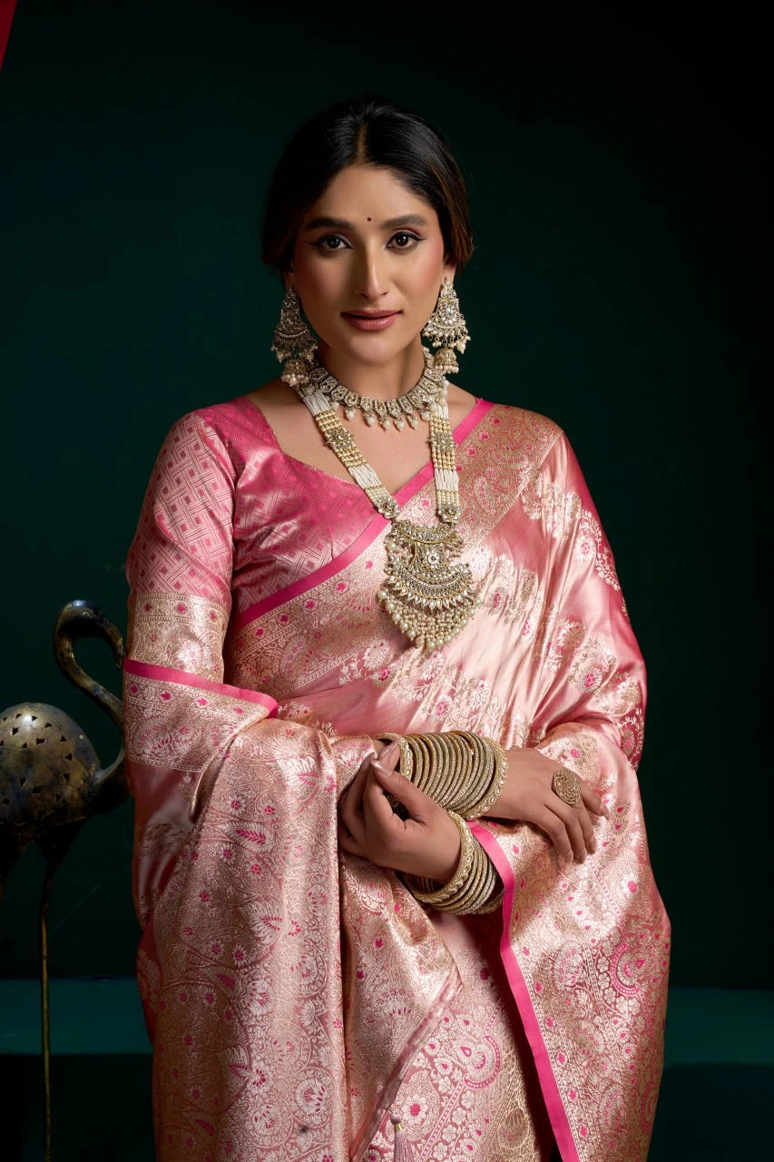 Woman in a pink saree with jewelry against a dark background