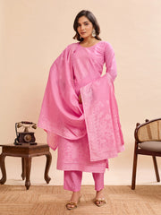 Woman wearing a pink traditional outfit with a scarf against a beige background