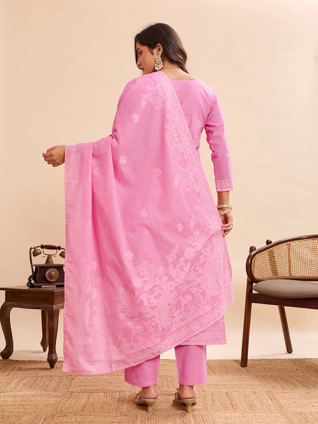 Woman wearing a pink traditional outfit with a beige background