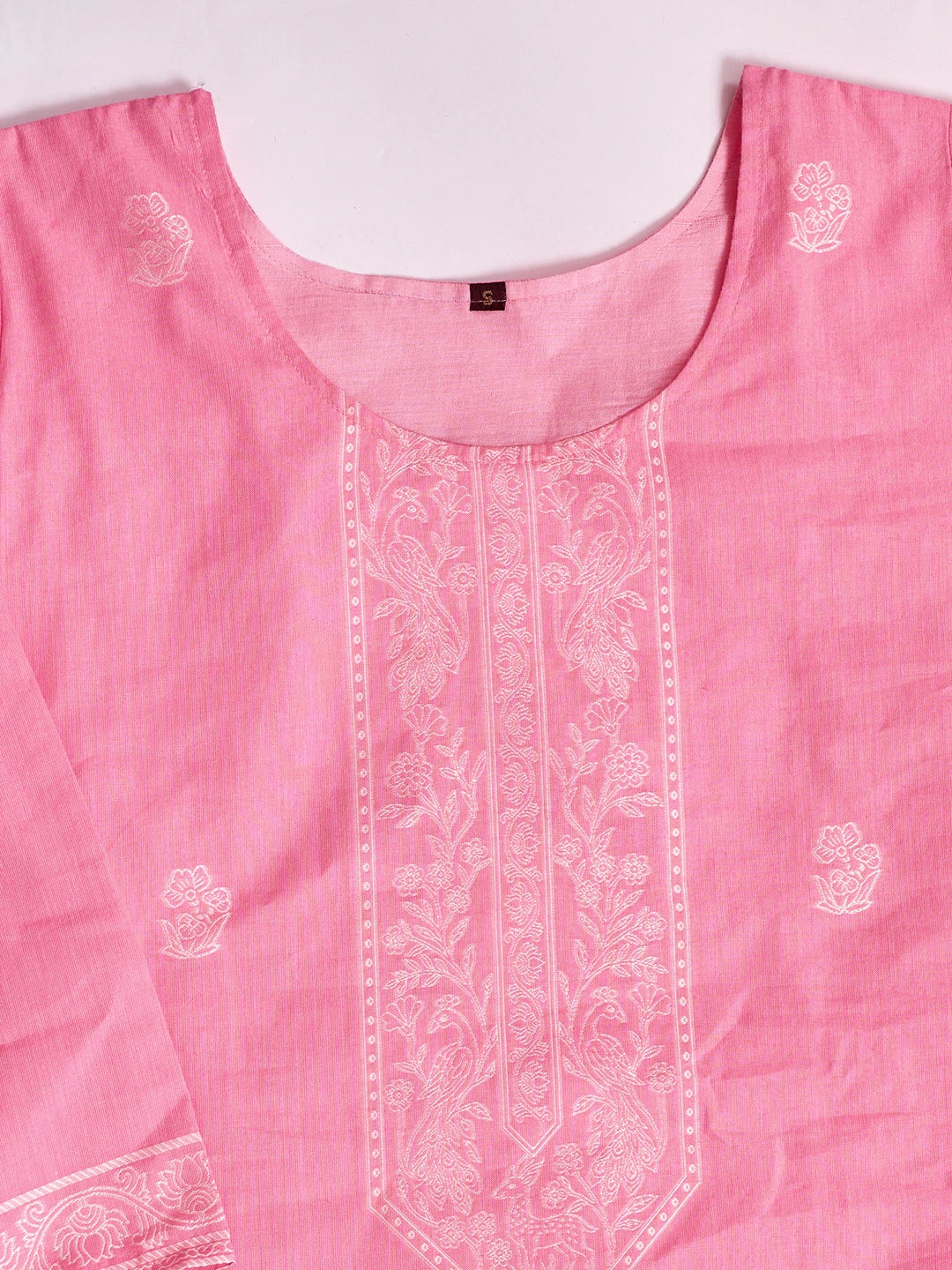 Pink fabric with white embroidery on a white background