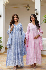 Two women wearing traditional outfits in a decorative indoor setting.