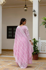 Woman in a pink saree standing in a decorative interior setting