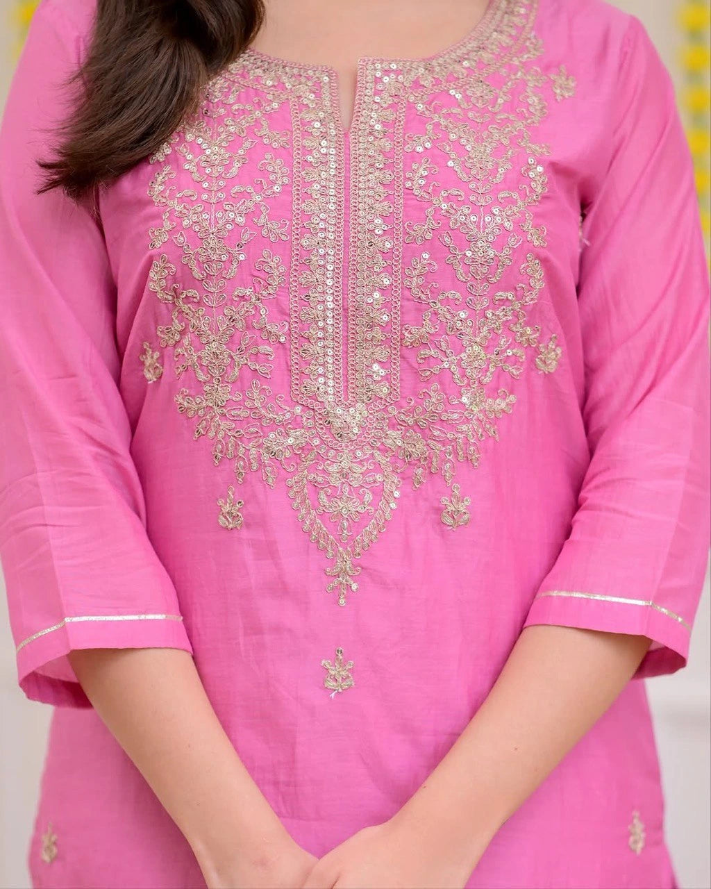 Pink embroidered traditional outfit with a blurred background