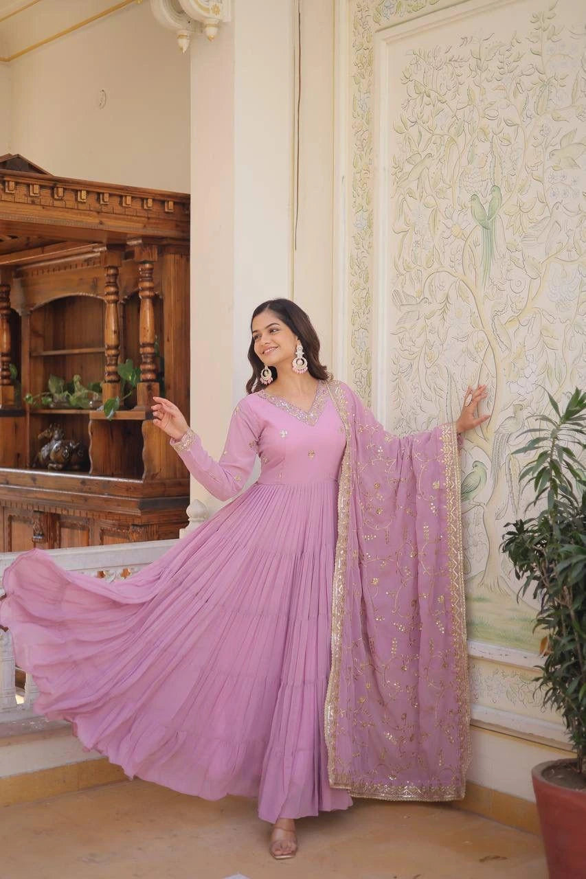 Woman in a pink traditional outfit standing in a decorated room.