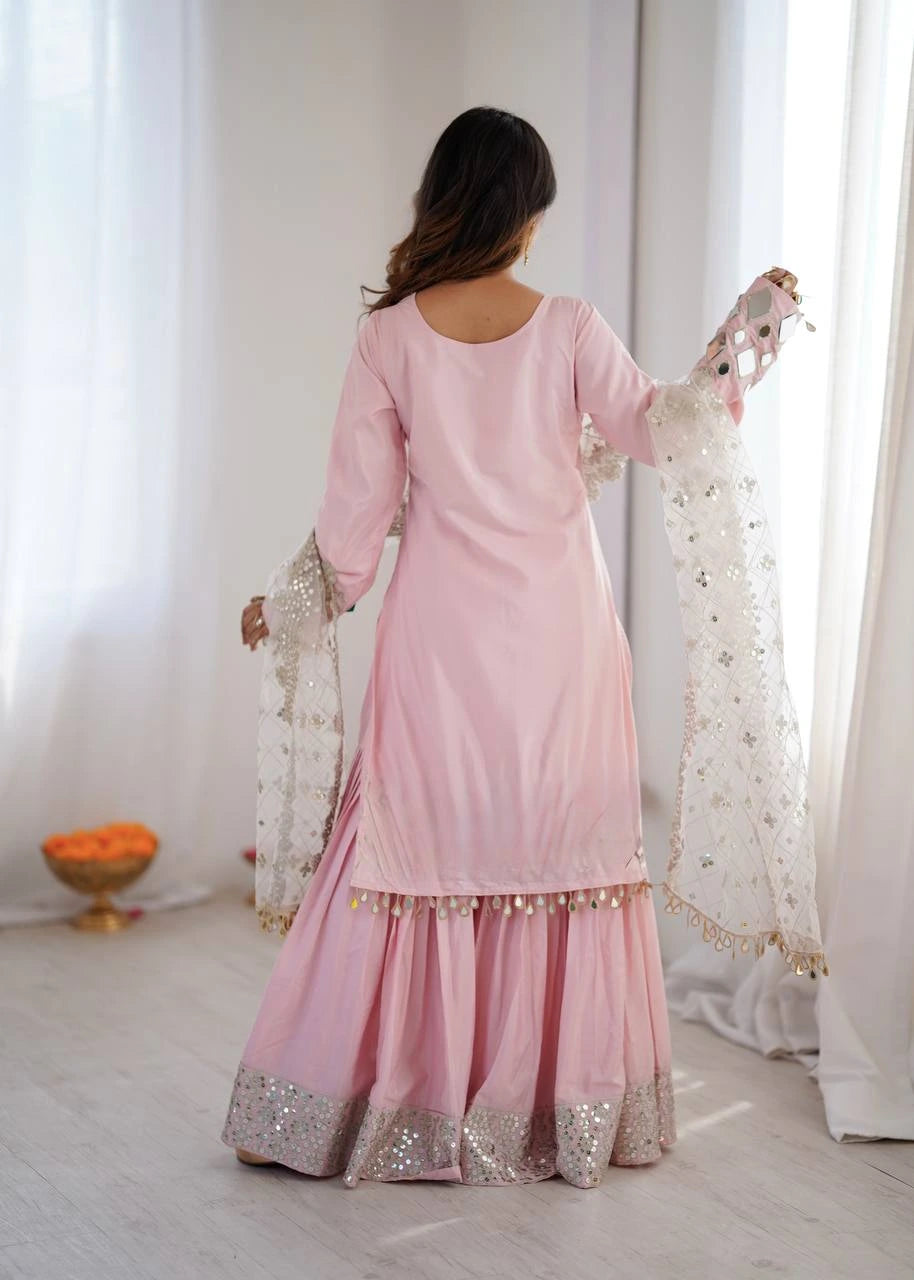 Woman wearing a pink traditional outfit with a white curtain background
