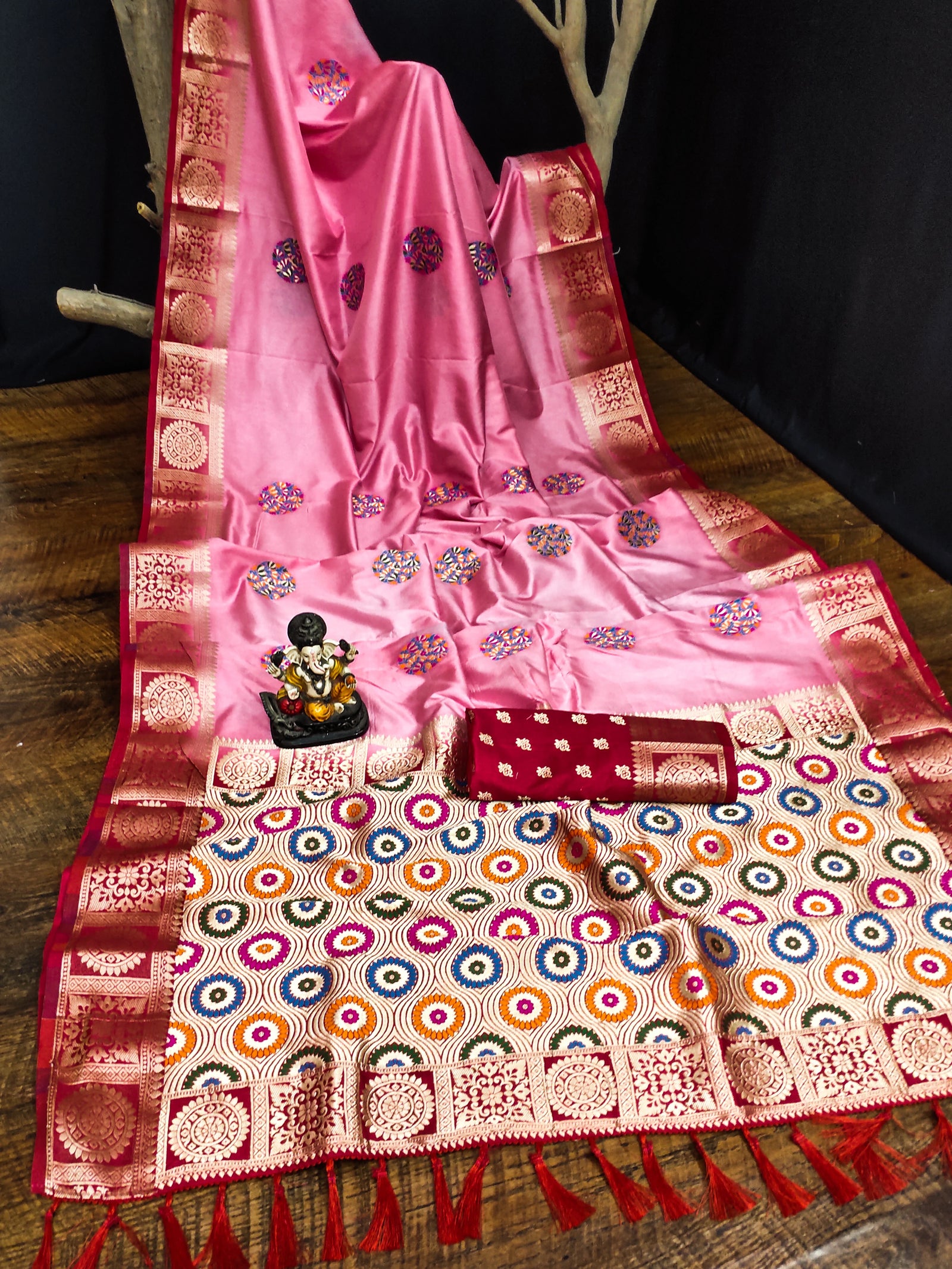 Pink saree with intricate patterns on a wooden surface