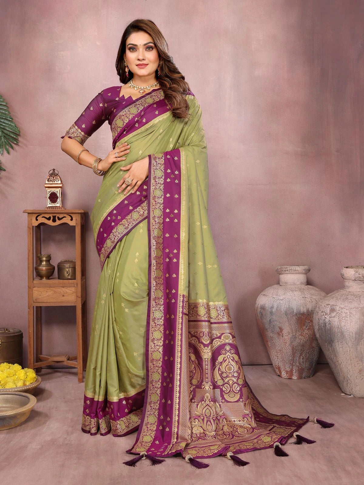 Woman wearing a green and purple saree with a neutral background