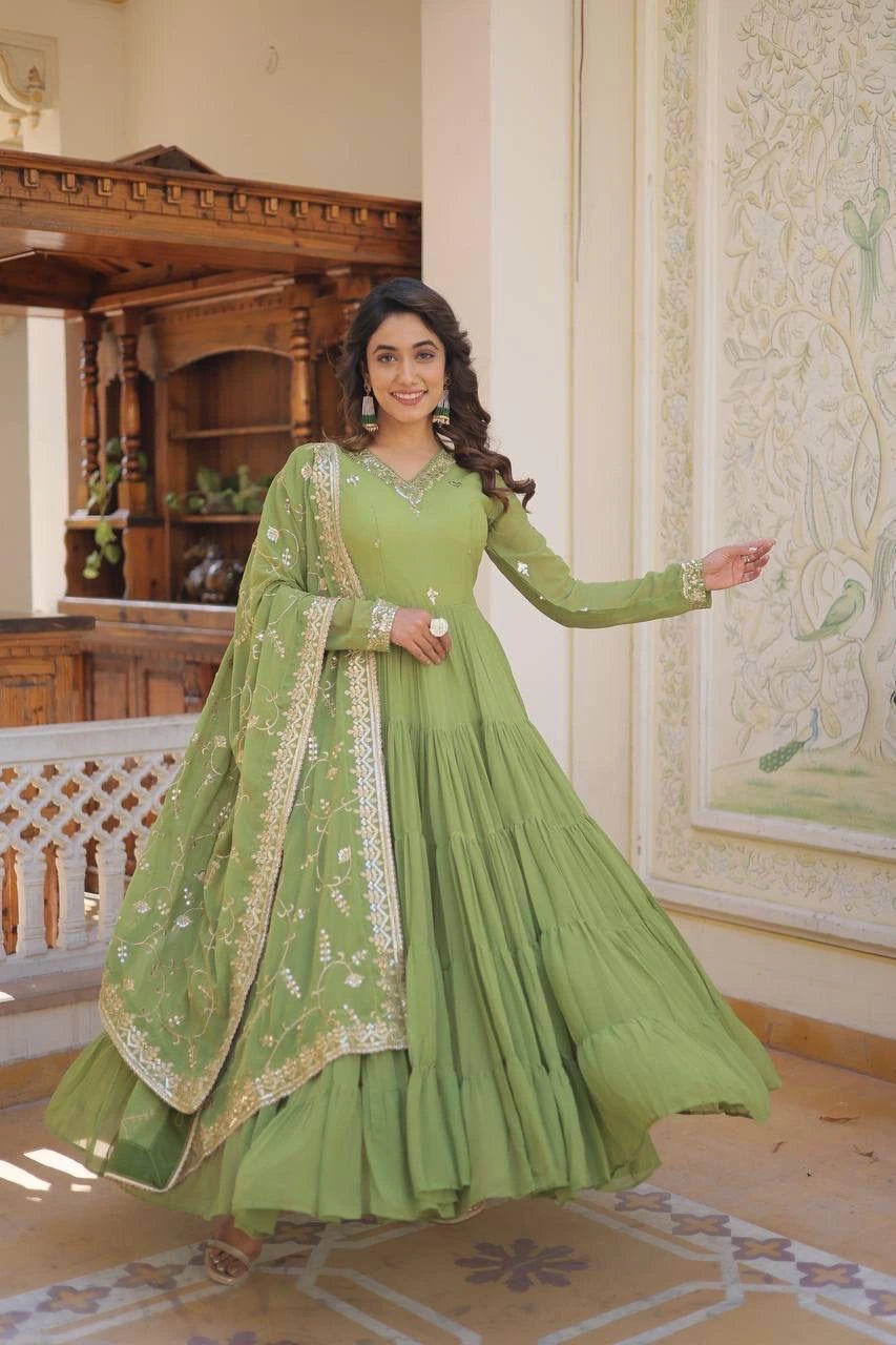 Woman in a green traditional outfit standing in an ornate room.