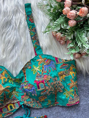 Decorative turquoise fabric with intricate patterns on a textured surface with flowers.