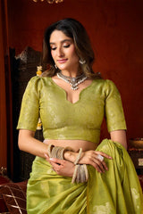 Woman in a green saree with jewelry against a warm-toned background