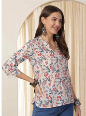 Woman wearing a floral blouse with a neutral background