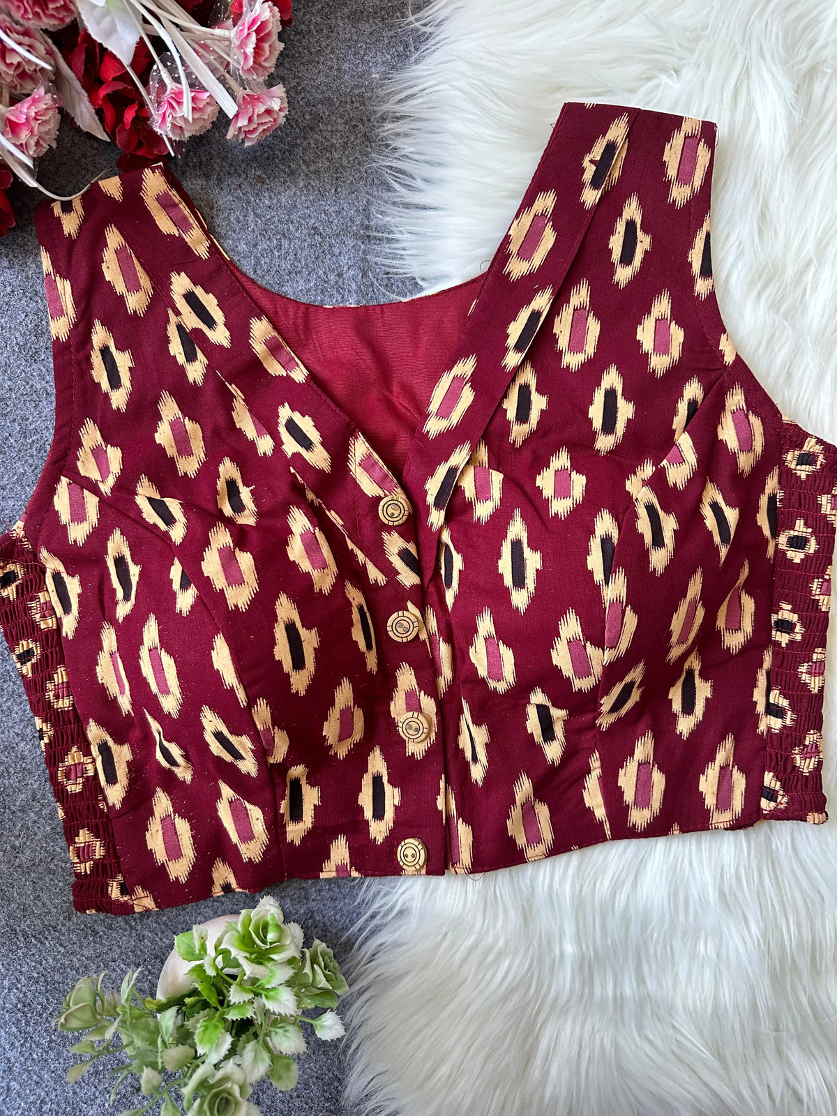 Red leopard print top on a textured surface with flowers and greenery.