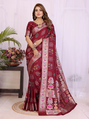 Woman wearing a maroon saree with floral patterns indoors.