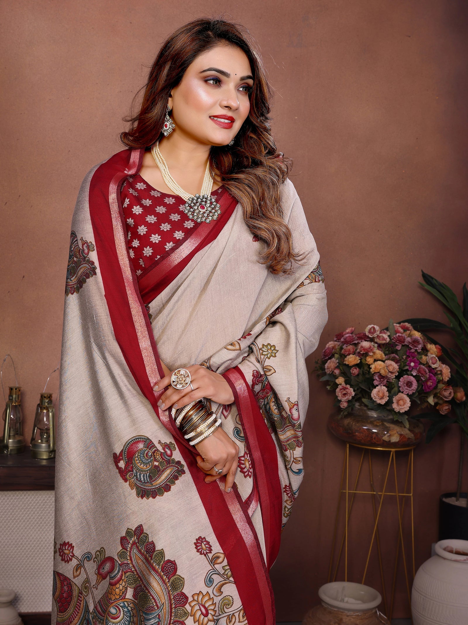 Woman in a traditional saree with a decorative pattern against a brown background