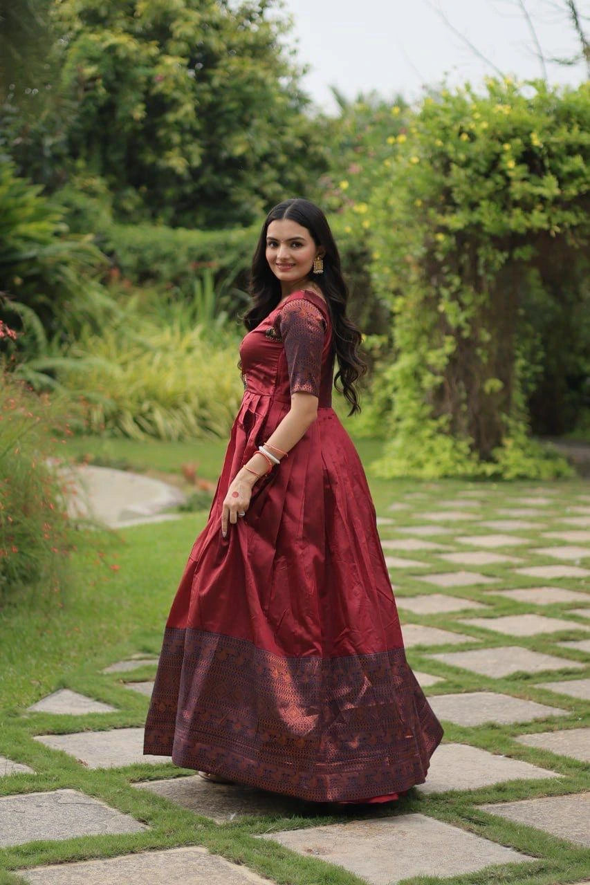 Woman in a red traditional outfit standing on a stone path with greenery in the background