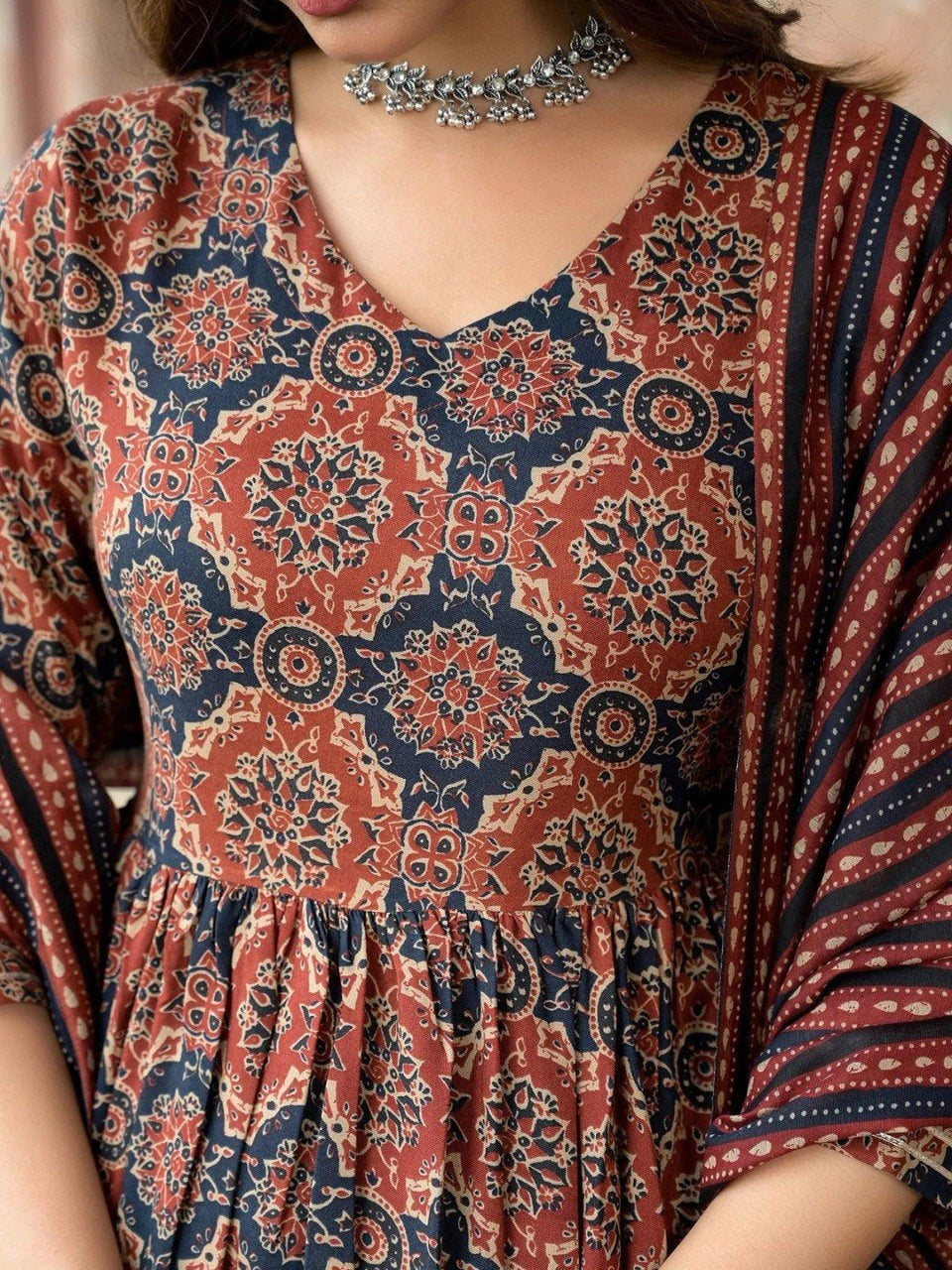 Close-up of a person wearing a patterned dress with a choker necklace.