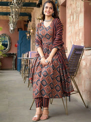 Woman in a patterned outfit sitting on a chair in an outdoor setting.
