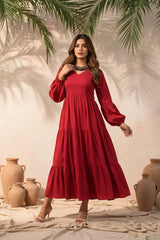 Woman in a red dress standing in a rustic setting with pots and plants.