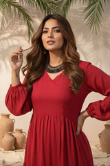 Woman in a red dress standing in front of decorative pots and greenery