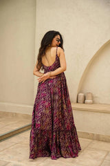 Woman wearing a patterned dress standing in a room with a neutral color scheme.