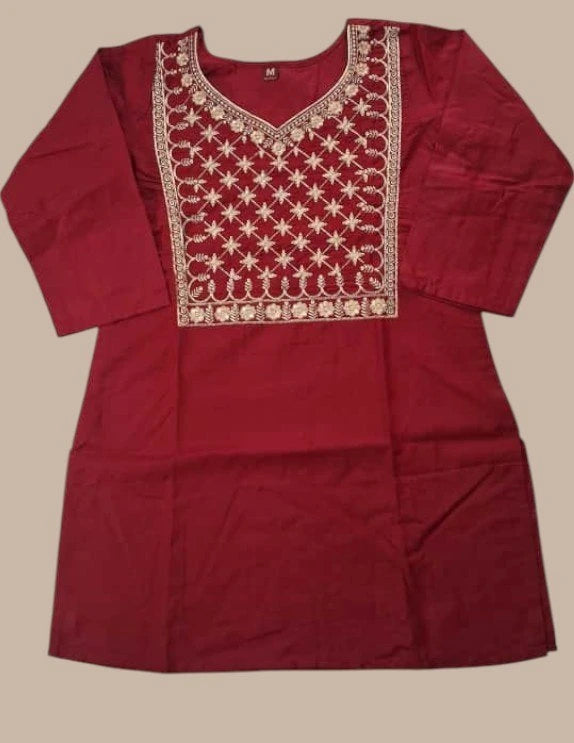 Maroon kurta with white embroidery on a beige background