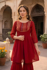 Woman in a red traditional outfit standing in front of an architectural background