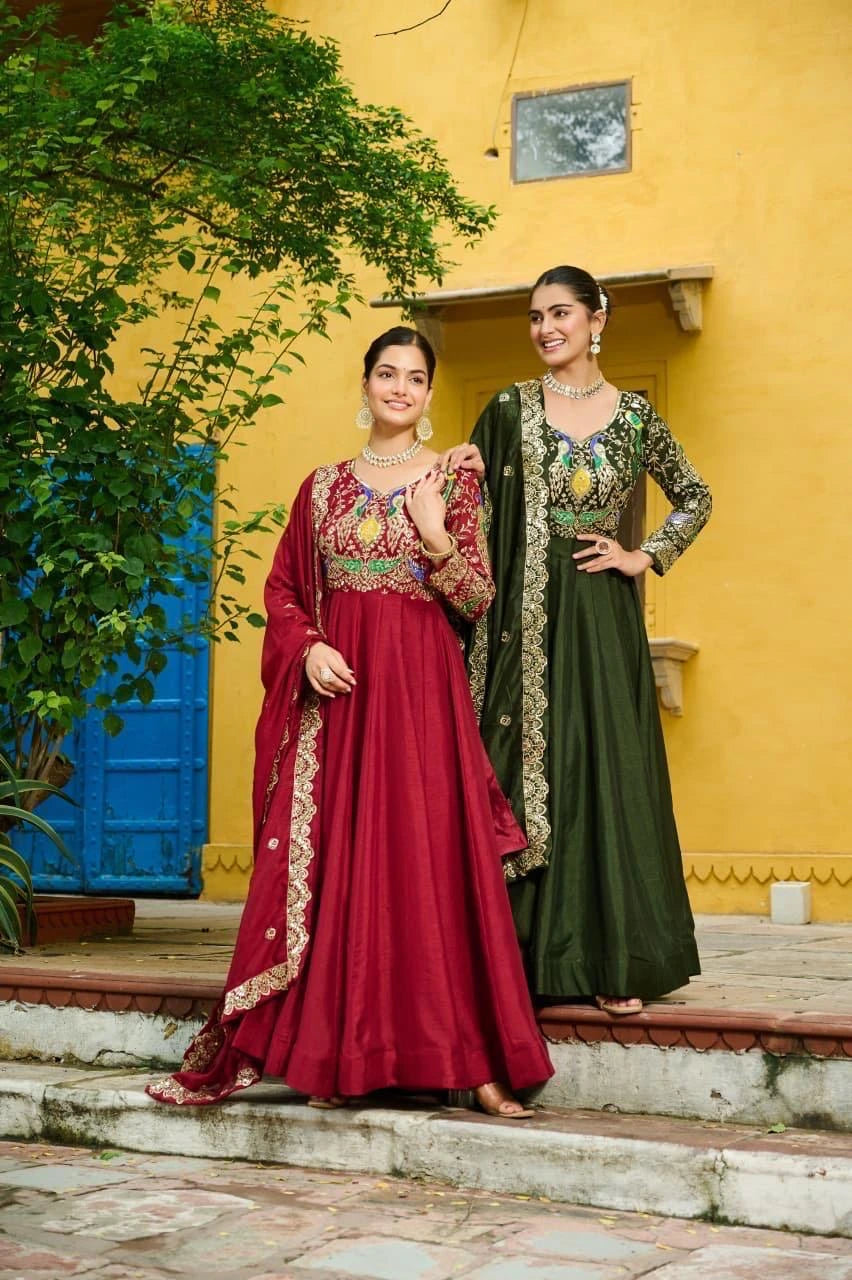 Two women in traditional outfits standing against a yellow wall with a blue door.