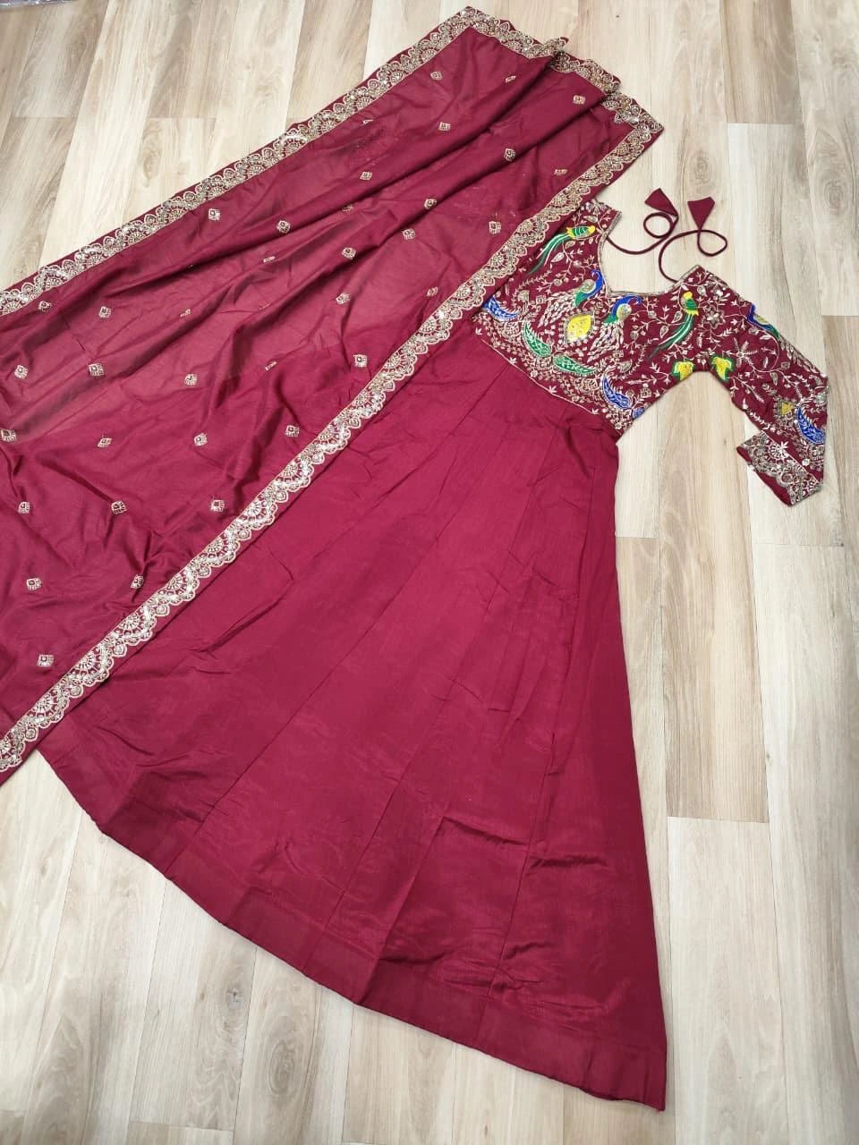 Maroon saree with embroidered blouse on a wooden floor