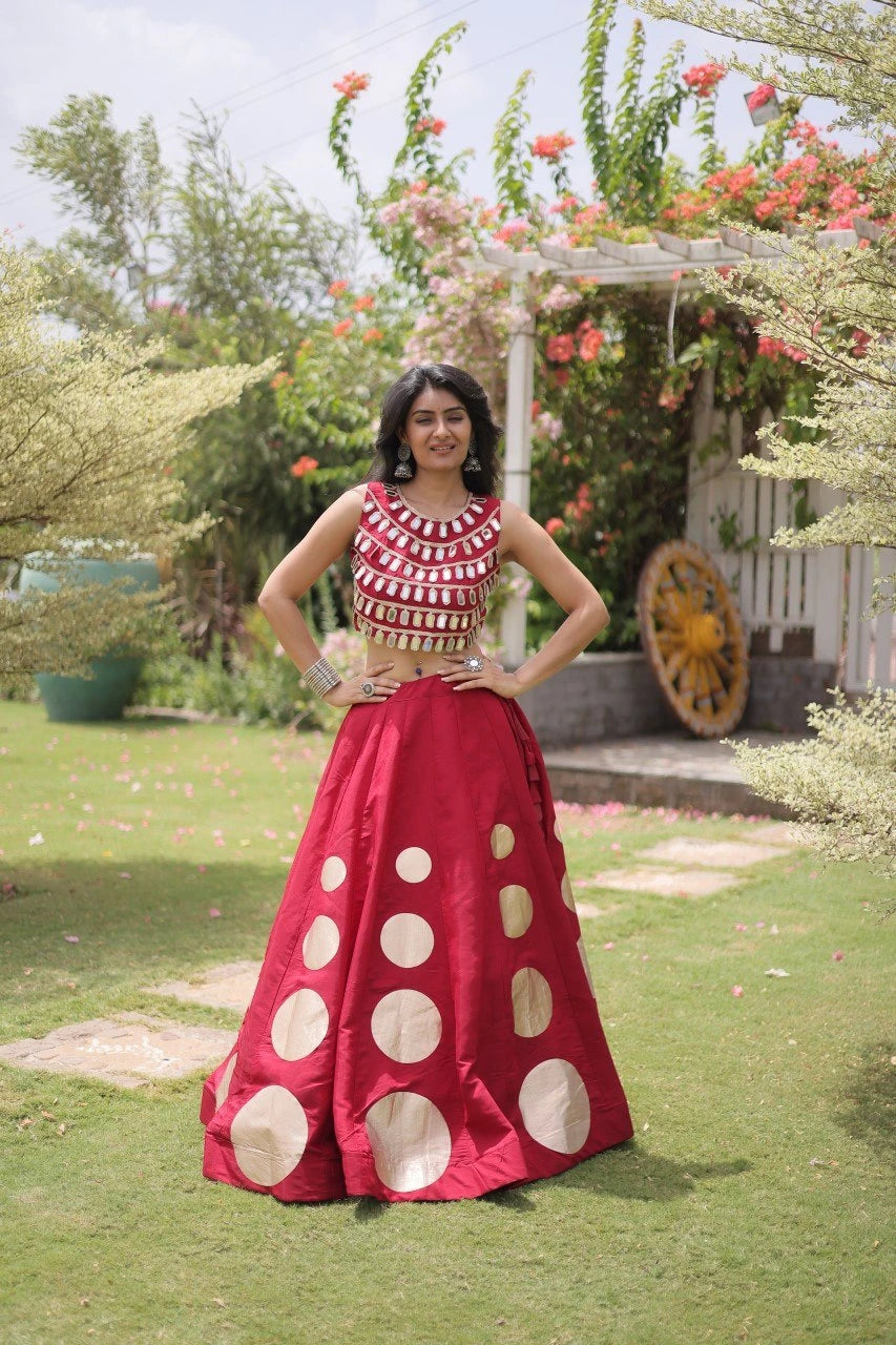 Elegant pink lehenga choli featuring a sleeveless mirror work blouse and a flared skirt with bold golden polka dot motifs.